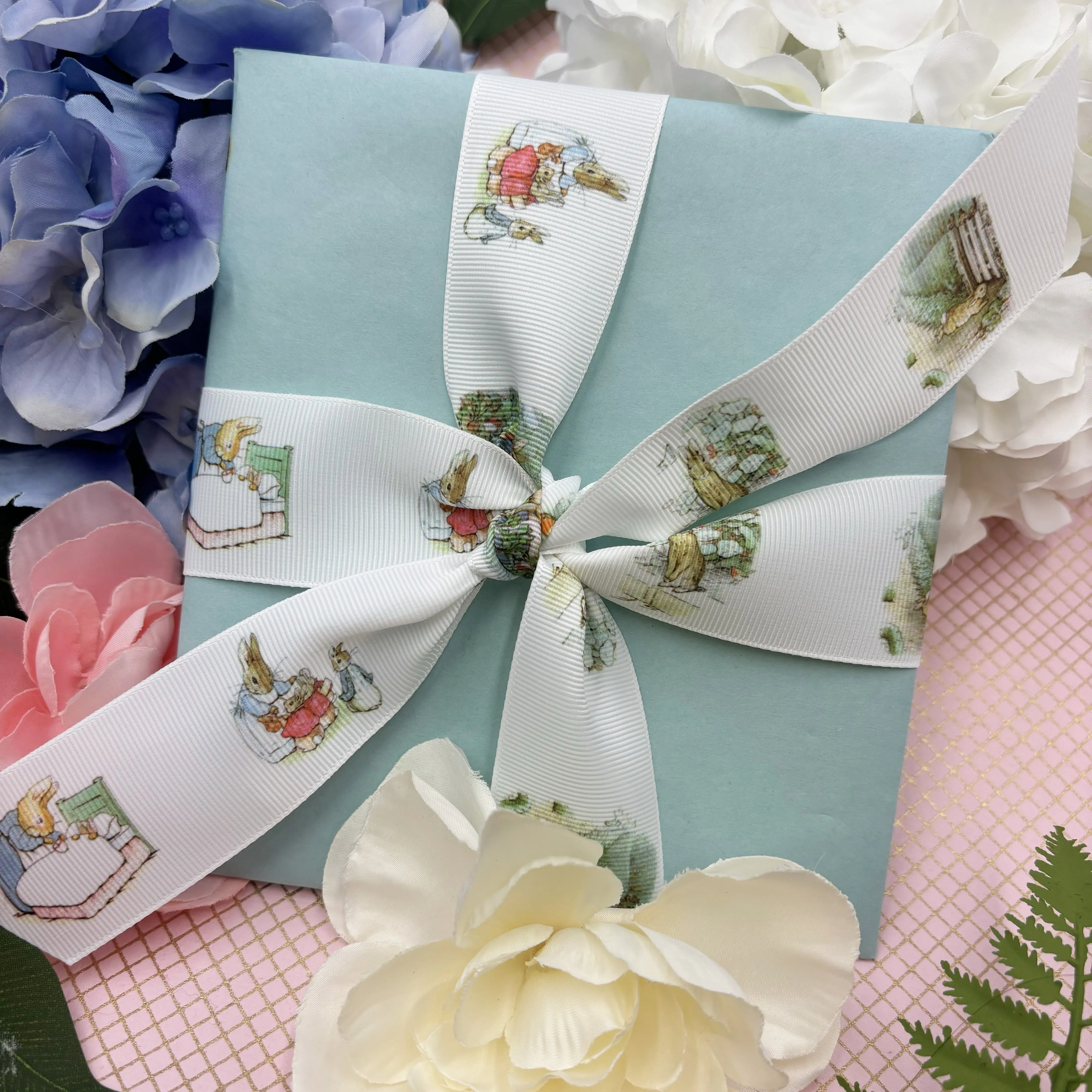 Bunny ribbon, rabbits in a blue jacket of storybook fame printed on 1.5" white satin and grosgrain